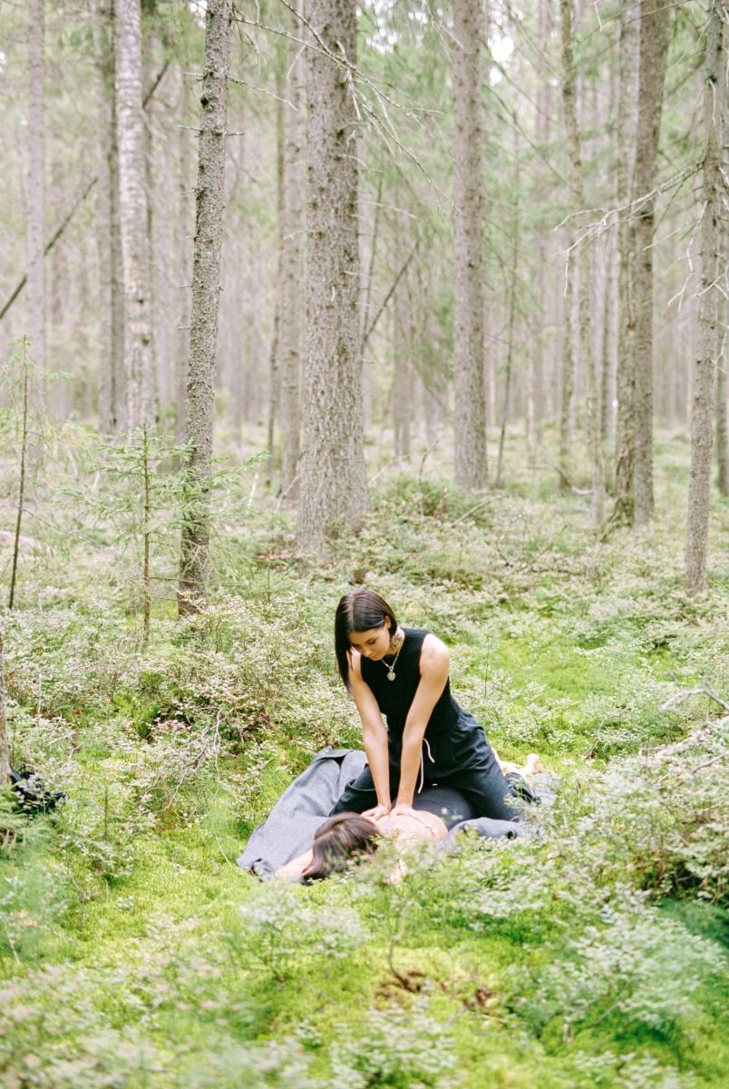 A serene outdoor massage session surrounded by lush greenery in a tranquil forest.