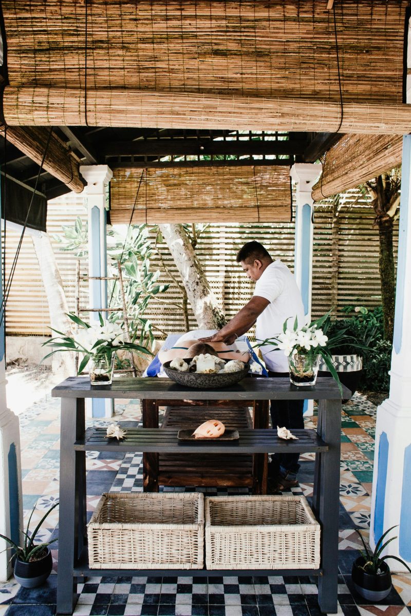 A relaxing outdoor massage session under a bamboo canopy in a tropical environment.