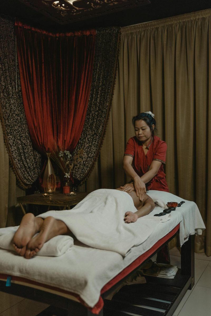 A soothing massage given by a professional therapist in a cozy spa setting with warm lighting.