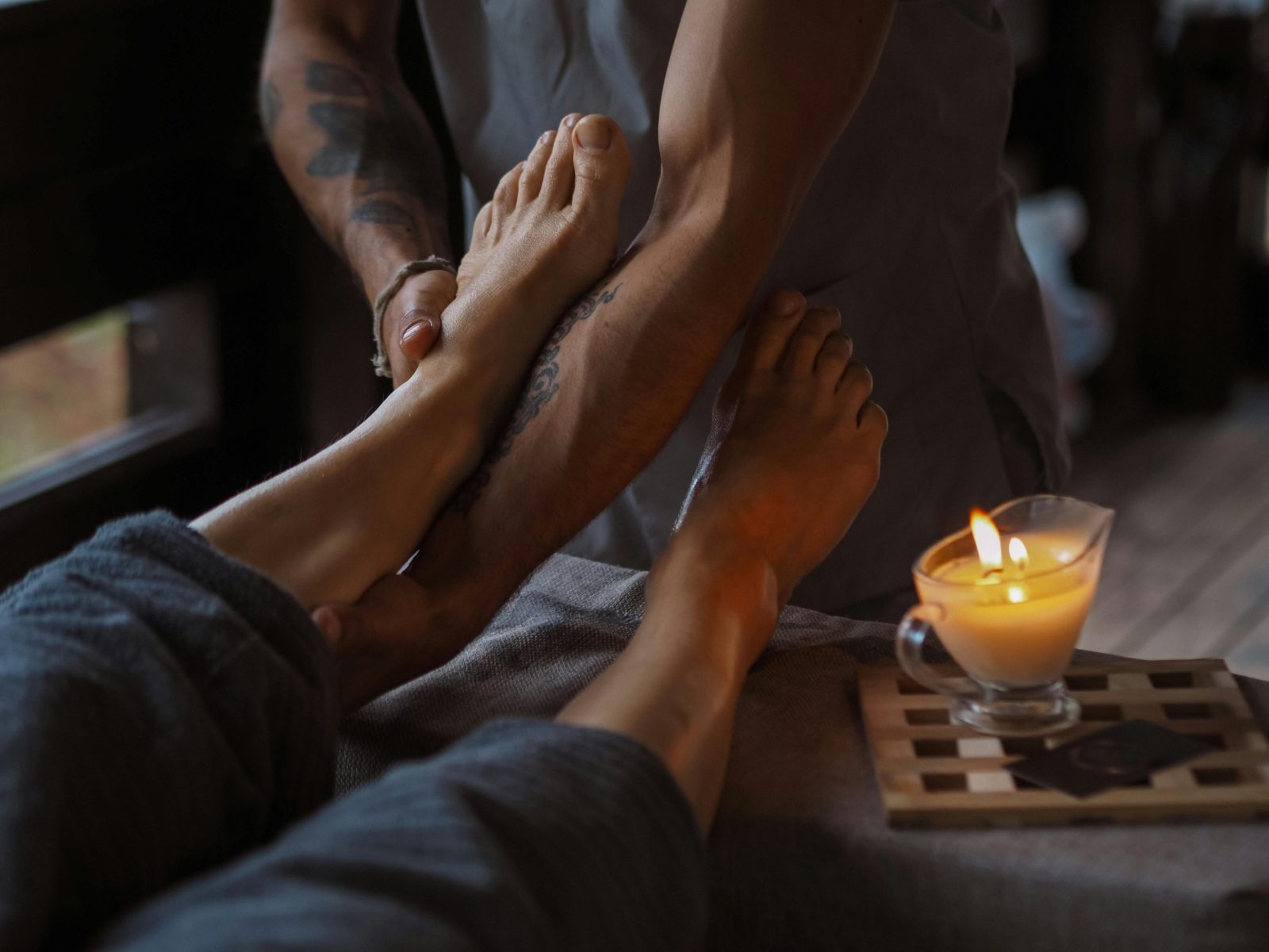 A serene foot massage session lit by candlelight, ideal for relaxation and spa treatments.