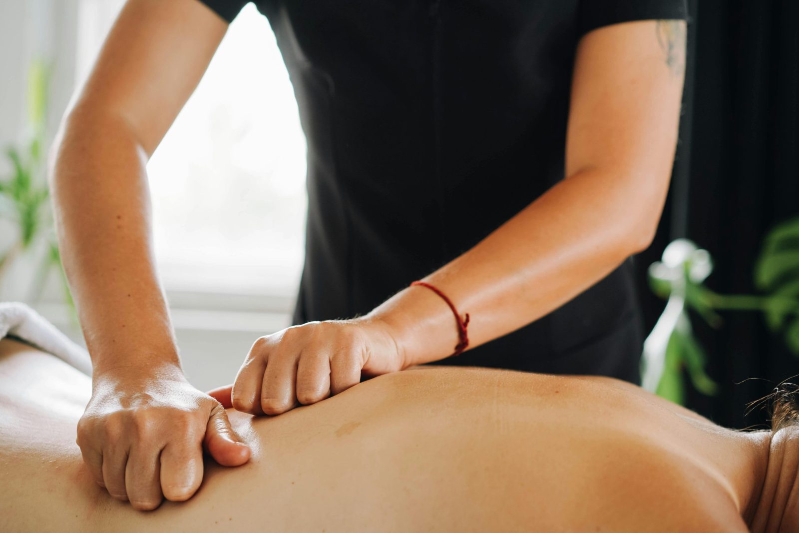 Close-up of a therapist performing a calming knuckle massage at a spa.